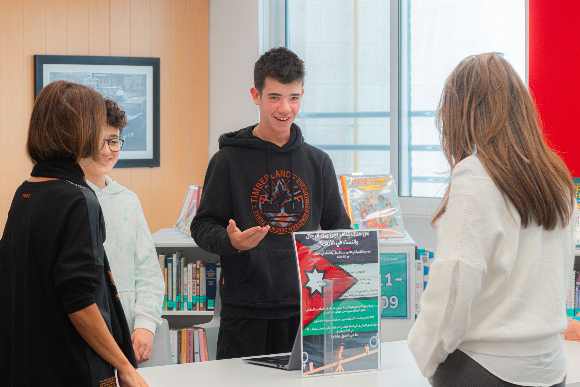 A student sitting at a table, eagerly participating in a discussion.